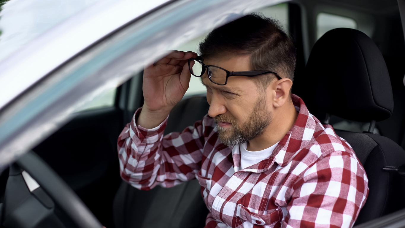 Uomo stressato alla guida si toglie gli occhiali